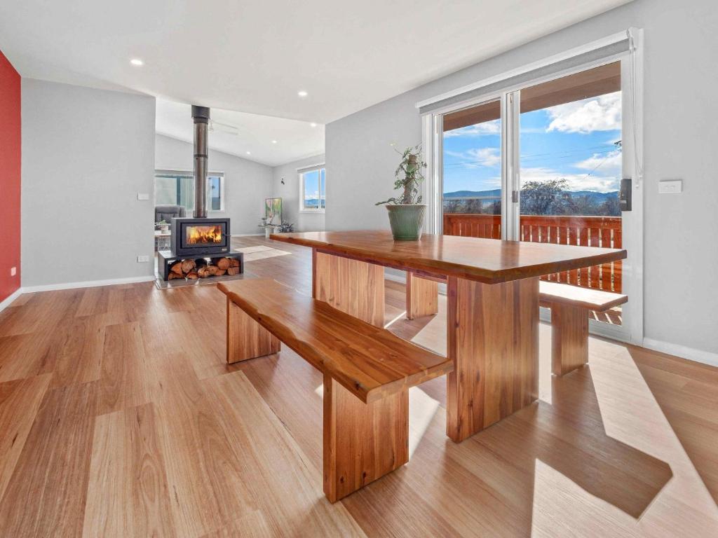 a dining room with a table and a fireplace at Allendale in Berridale
