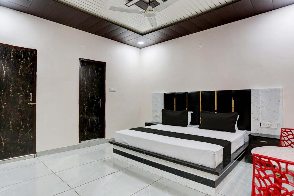 een slaapkamer met een groot bed en een rode stoel bij OYO Flagship Hotel A&S in Rohtak