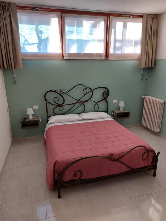 a bedroom with a bed with a red blanket at Terrace house appartamento mq 80 adiacente ospedale e clinica in Piacenza