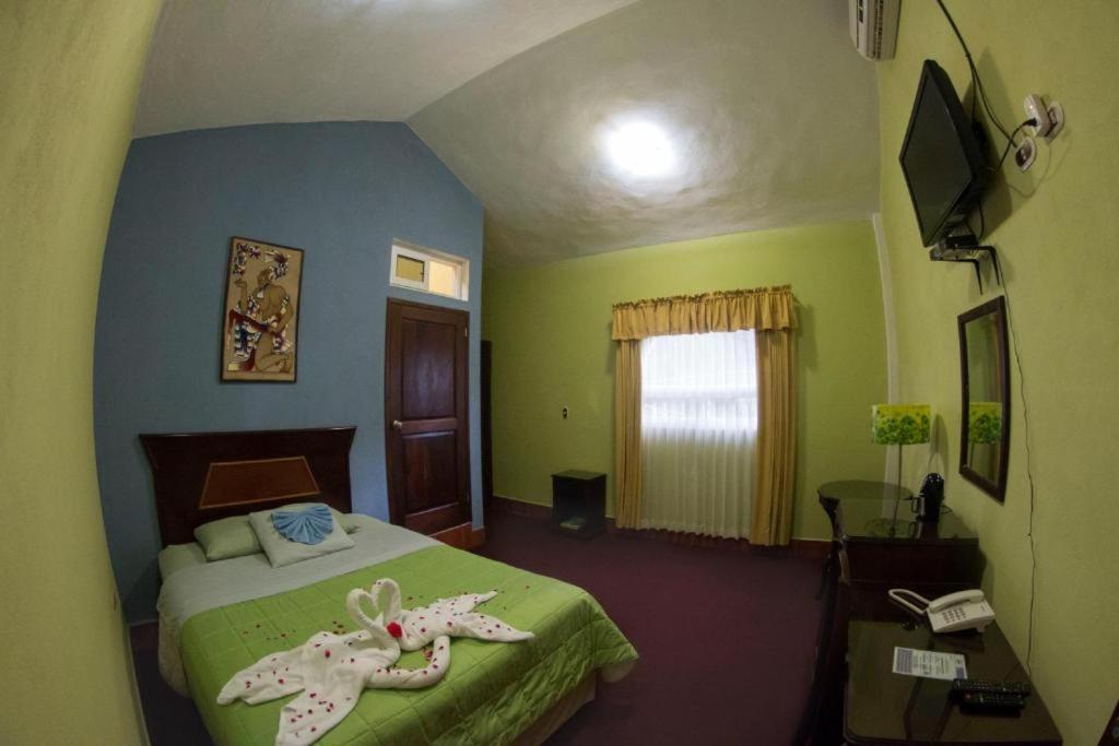a bedroom with a bed and a desk and a phone at Ribiera del Lago Peten Itza in Flores