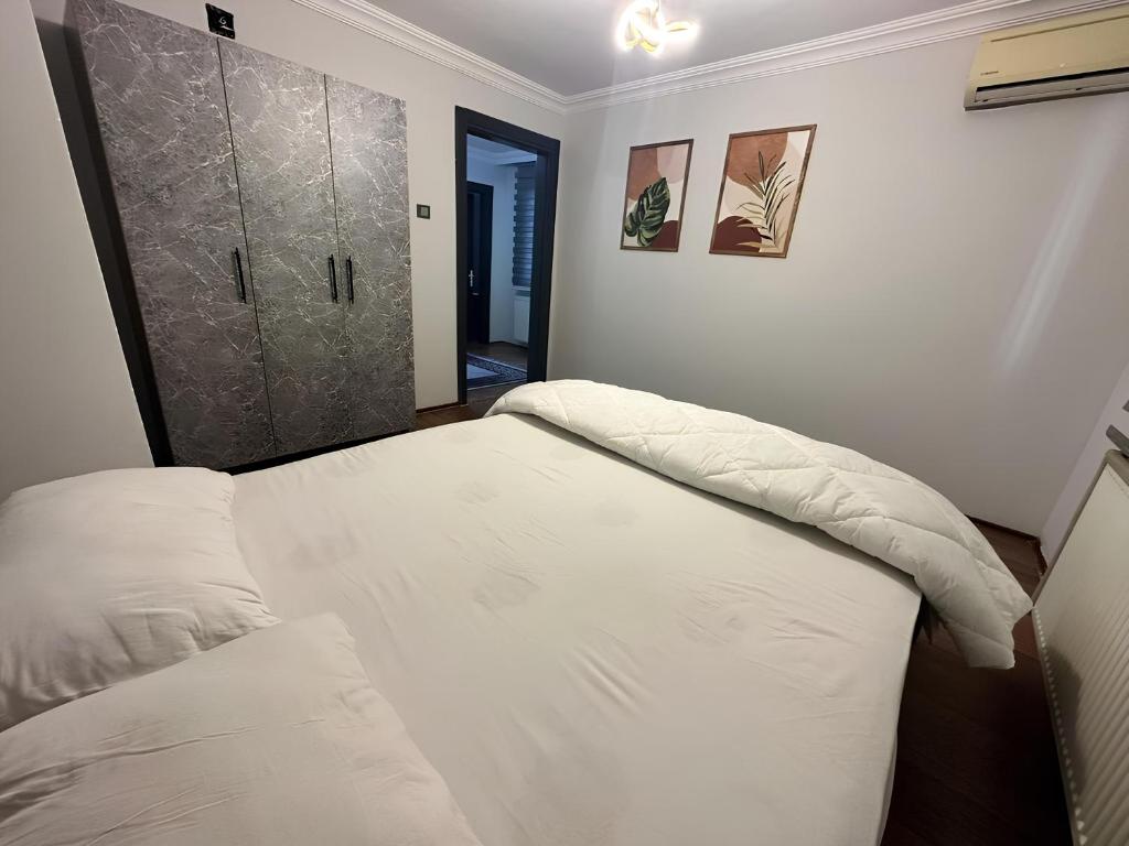 a bedroom with a bed and a door to a hallway at Meydan Suite Apartments in Trabzon