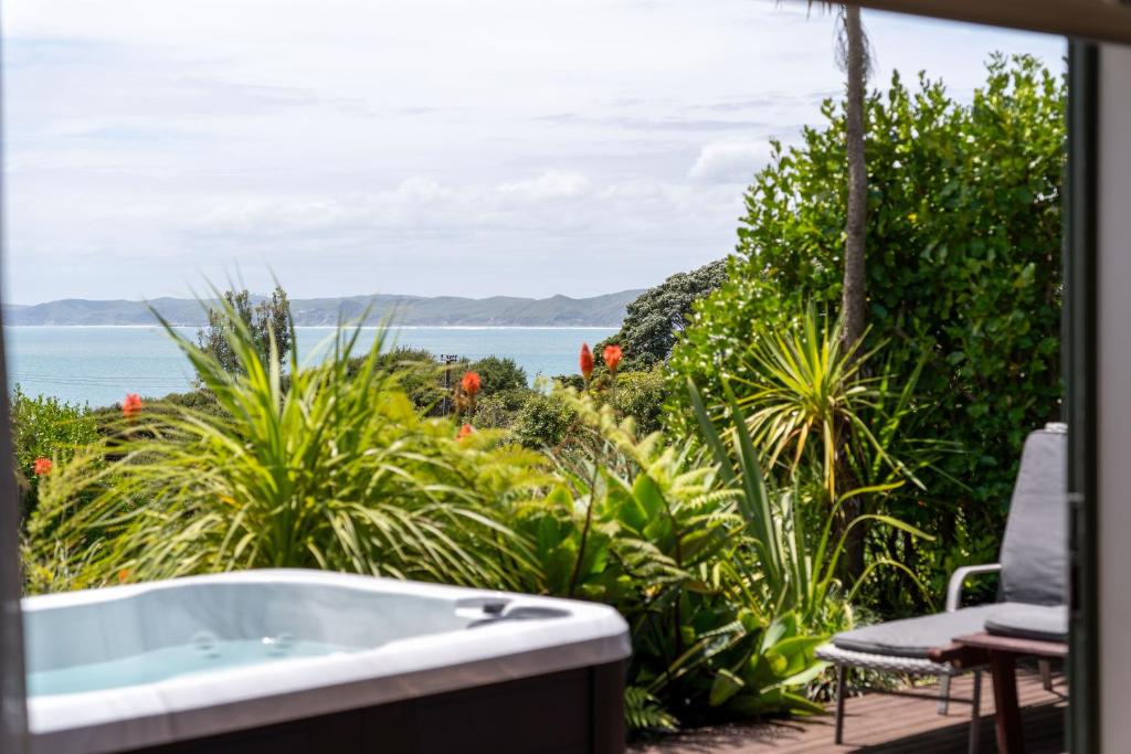a bath tub with a view of the ocean at Koru Lodge in Raglan