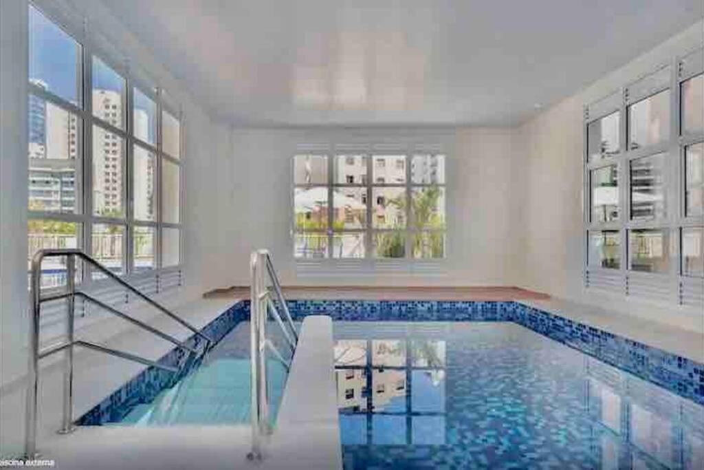 een groot zwembad in een witte kamer met ramen bij 1709 - Rentaqui Apartamento Comfort Bela Vista in Sao Paulo