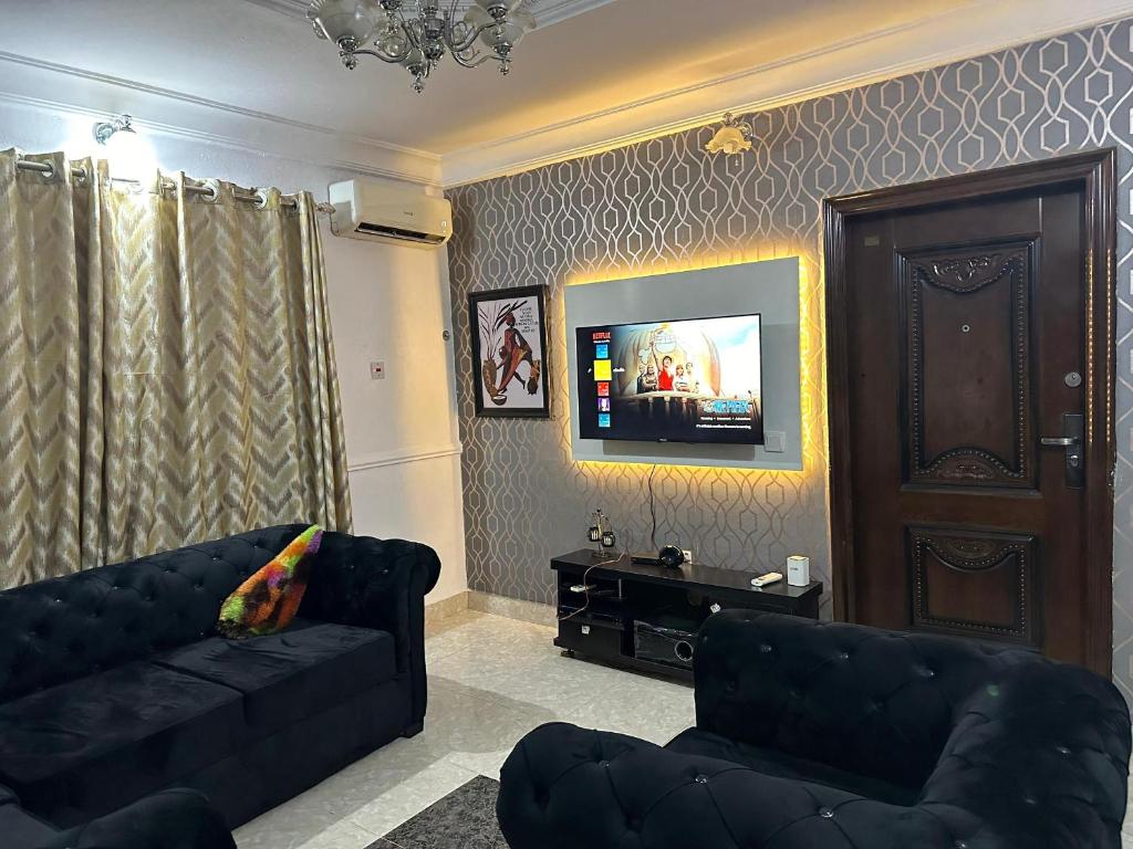 a living room with a couch and a flat screen tv at TSOLID HOMES ( SHORTLET & APARTMENT) in Ibadan