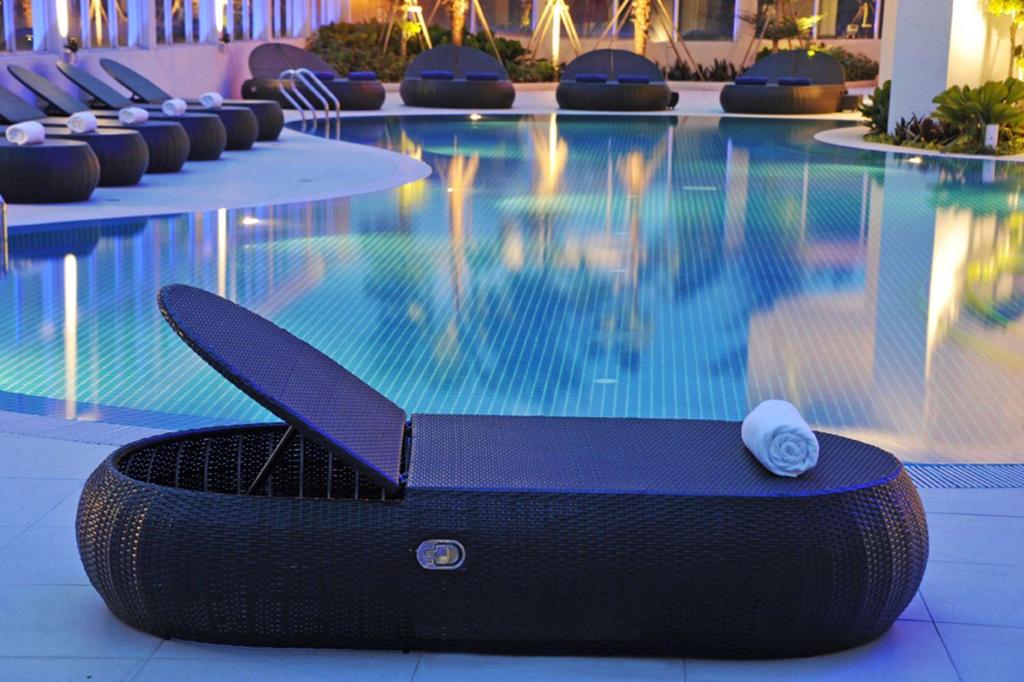 a swimming pool with a laptop sitting next to it at Wyndham Grand Bangsar Kuala Lumpur in Kuala Lumpur