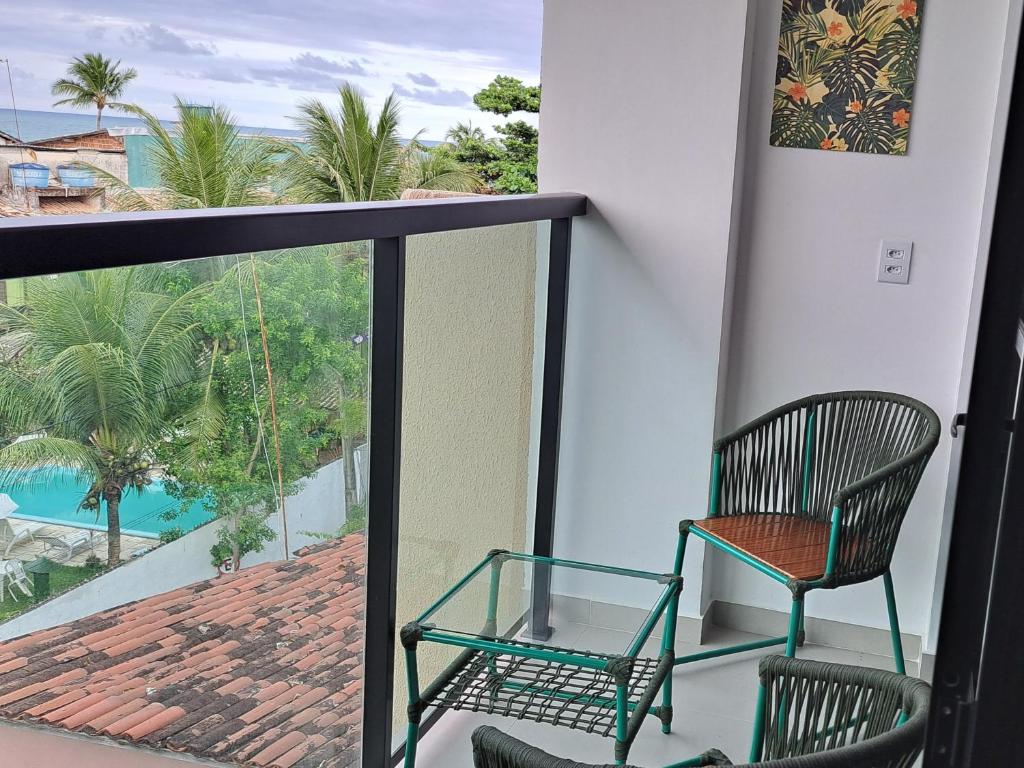 balcone con 2 sedie e vista sulla piscina di Maraca Beach Residence 1 apartamento 401 a Porto De Galinhas