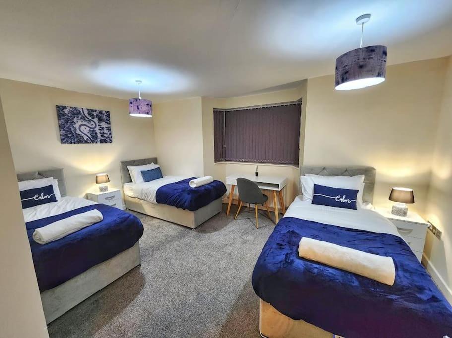 een hotelkamer met 2 bedden en een bureau bij Modern 2 Bed Apartment - Sleeps up to 5 - Coventry - Business and Leisure Stays in Coventry