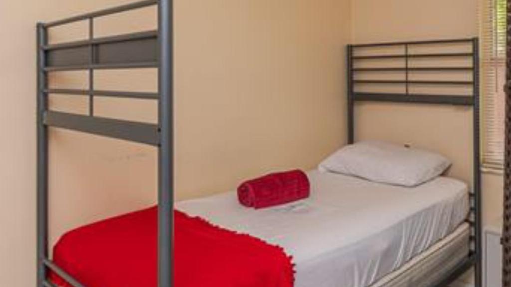 a bedroom with a bunk bed with a red blanket at Crocodhouse in Fort Lauderdale