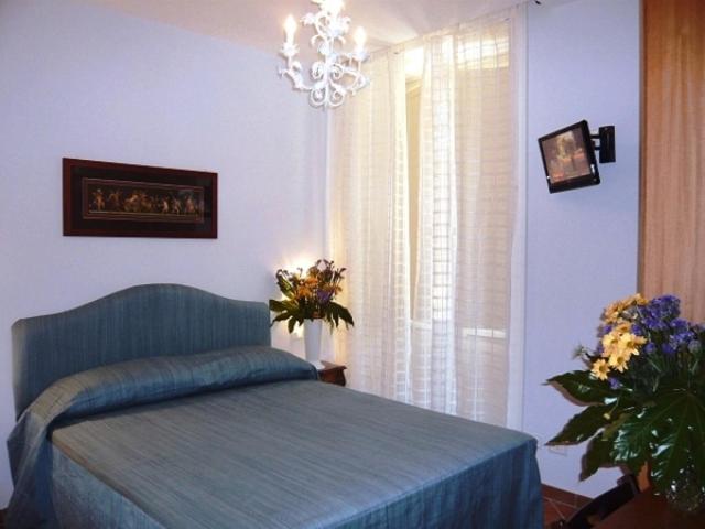 ein Schlafzimmer mit einem Bett und einem Fenster mit Blumen in der Unterkunft DolceVitaSorrento Guest House in Sorrent