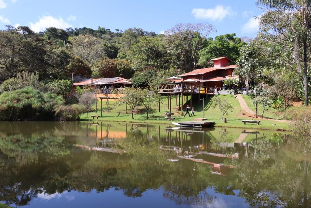 a view of a house from the lake at Ecopousada Serra Verde in Glaura