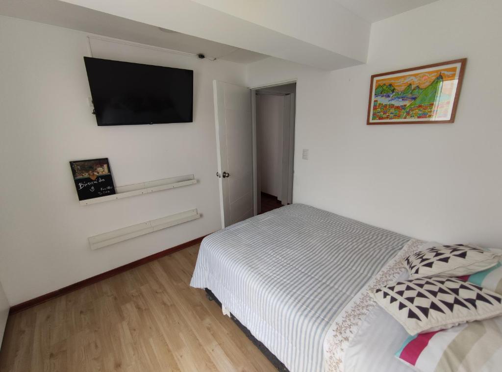 a bedroom with a bed and a flat screen tv at Habitación Isolina in Lima