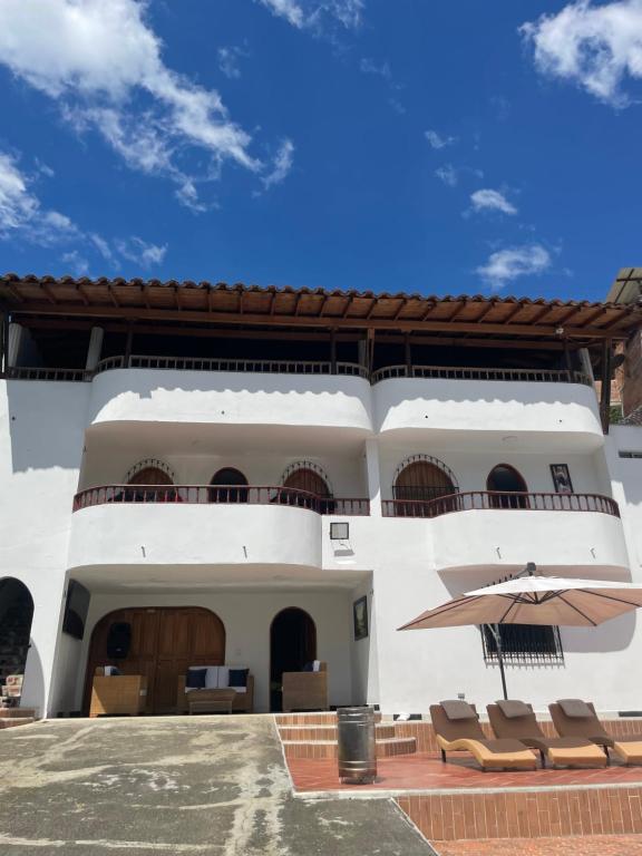 un bâtiment avec un patio avec des chaises et un parasol dans l'établissement La torrecita, à Barbosa