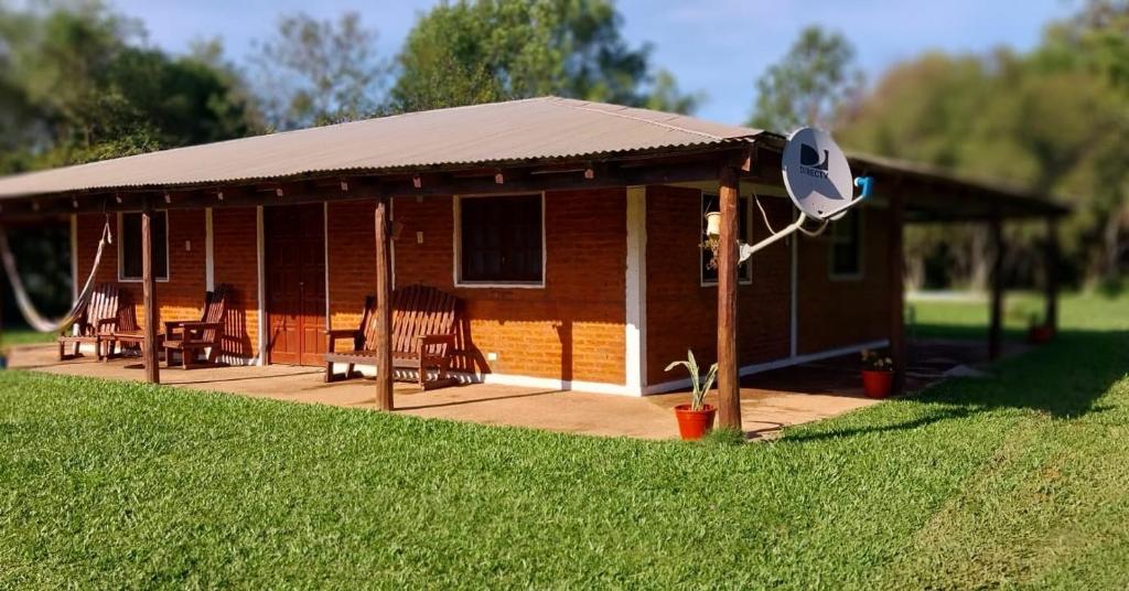 a small cabin with a roof on a lawn at Cabaña Iberá in Colonia Carlos Pellegrini