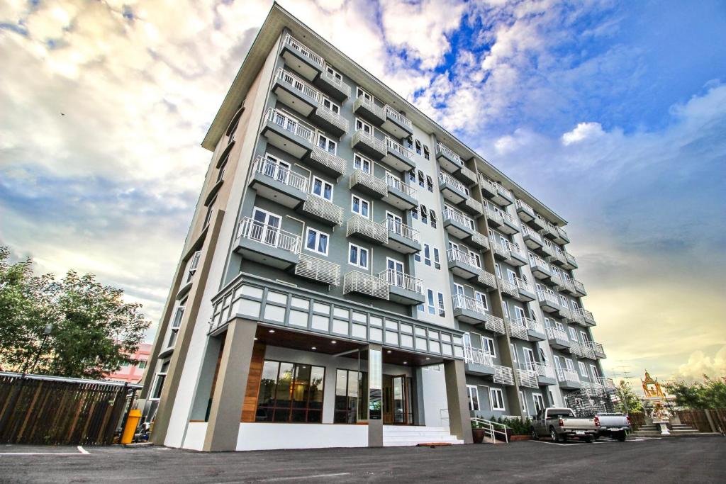 um grande edifício de apartamentos com muitas janelas em Tai-Shan Suites em Ratchaburi