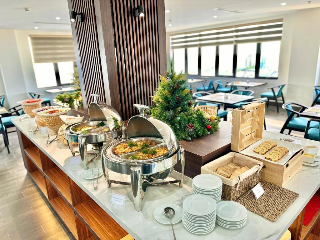 A breakfast buffet island serves hot dishes, baked goods and cereals in a bright dining room.