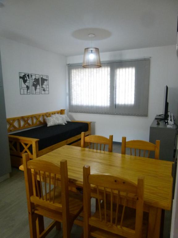 Zimmer mit einem Tisch, Stühlen und einem Bett in der Unterkunft Departamento RUKA-9 in San Martín de los Andes