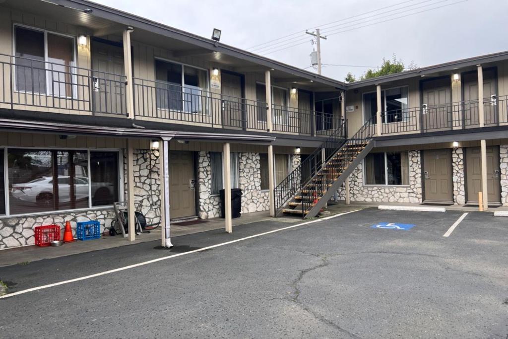 an apartment building with a staircase in a parking lot at Anchor Bay Inn By OYO Reedsport in Reedsport