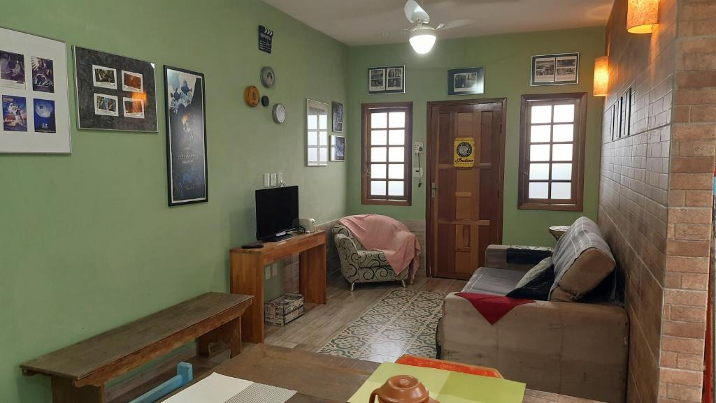 uma sala de estar com um sofá e uma televisão em Aconchegante Casa em São Lourenço