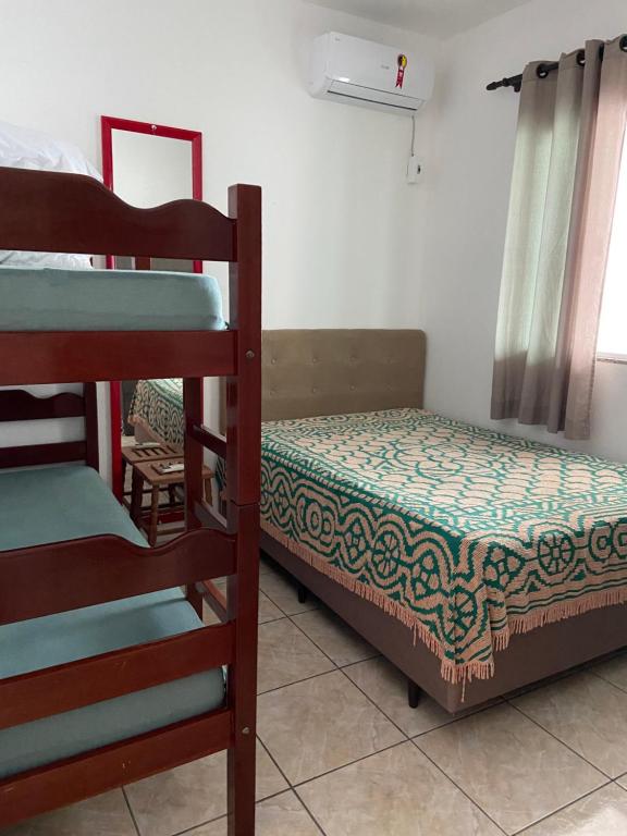 a bedroom with two bunk beds and a bed at Casa 2 Quartos na Armação in Governador Celso Ramos