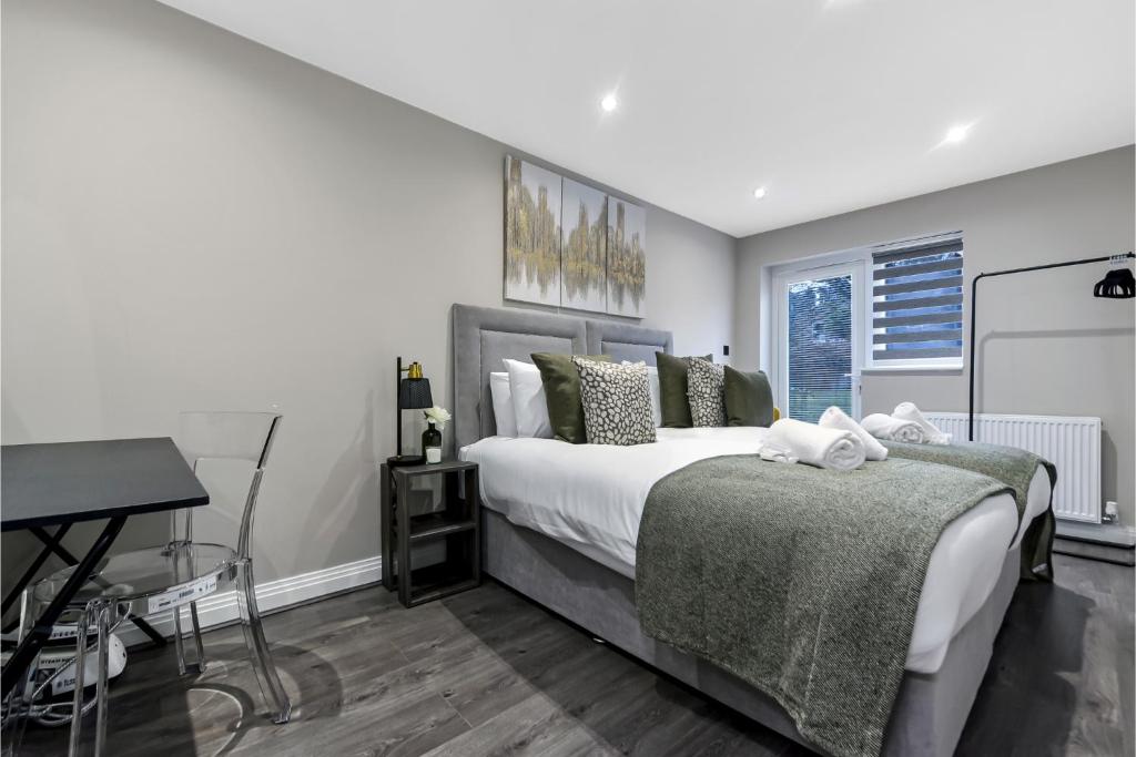 1 dormitorio con 1 cama grande y escritorio en City Paradise- 3 BDR Flat w/ Spacious Garden en Greenford