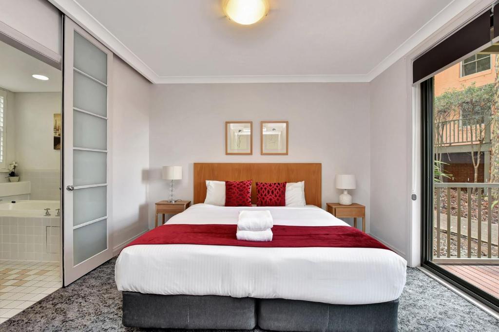 1 dormitorio con 1 cama grande y baño en Villa Spa Executive 1br Burgundy located within Cypress Lakes Resort en Pokolbin