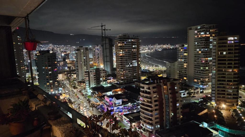uma vista para uma cidade à noite com luzes em Habitación duerme y disfruta junto al mar em Iquique