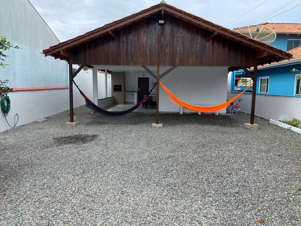 un porche con hamaca y un edificio en BS01- Casa Aconchegante| Equipada| Churrasqueira|, en Balneário Barra do Sul