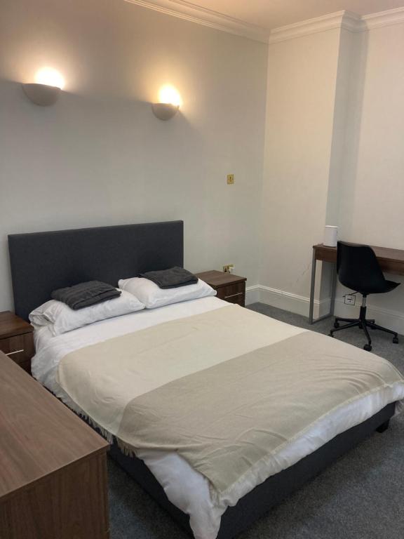 a bedroom with a large bed and a desk at Oxford Street Two Bed Apartment in London
