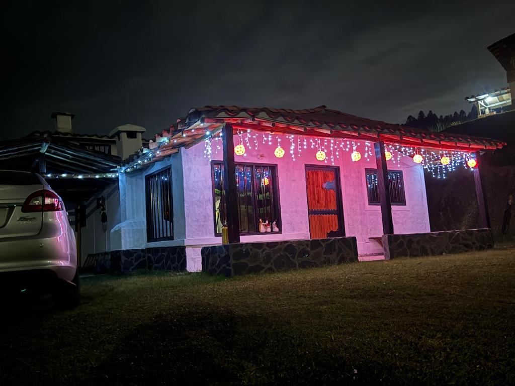 a house covered in christmas lights at night at La Colina Magik in Guarne