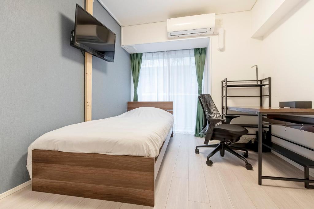 une chambre avec un lit, un bureau et un ordinateur dans l'établissement Brilliant MK- III, à Tokyo