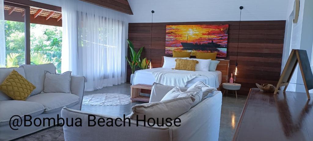 Bombua Beach House في لوجنفيل: غرفة معيشة بها سريرين وأريكة