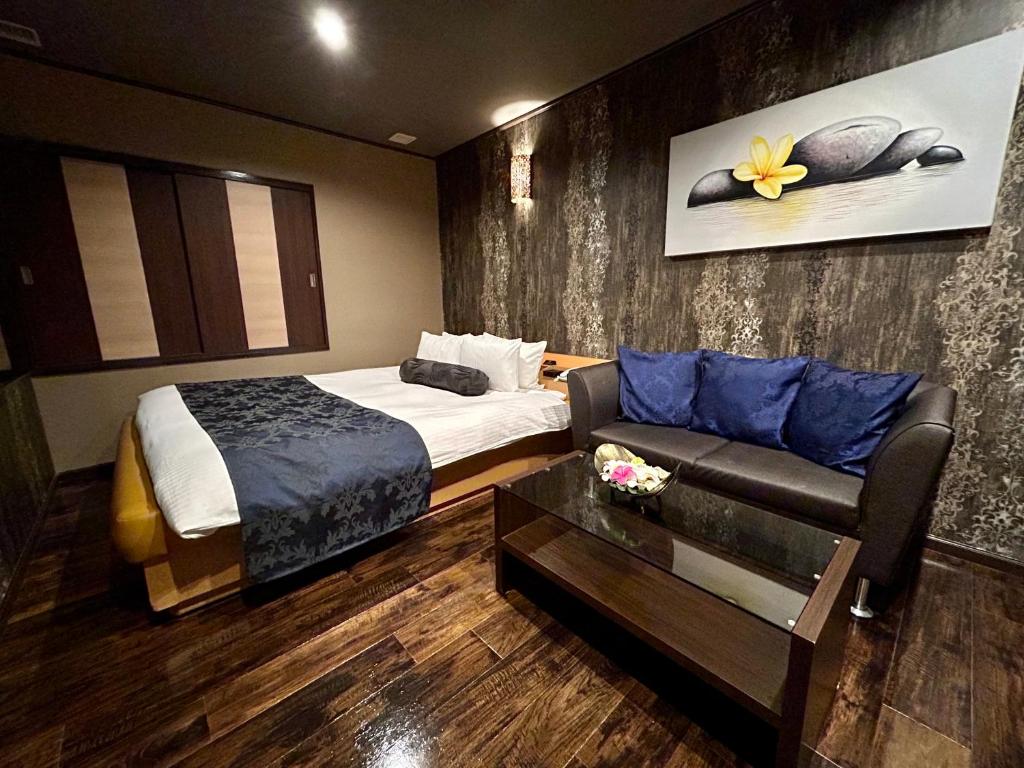 ein Hotelzimmer mit einem Bett und einem Sofa in der Unterkunft Hotel Asian Color (Adult Only) in Tokio