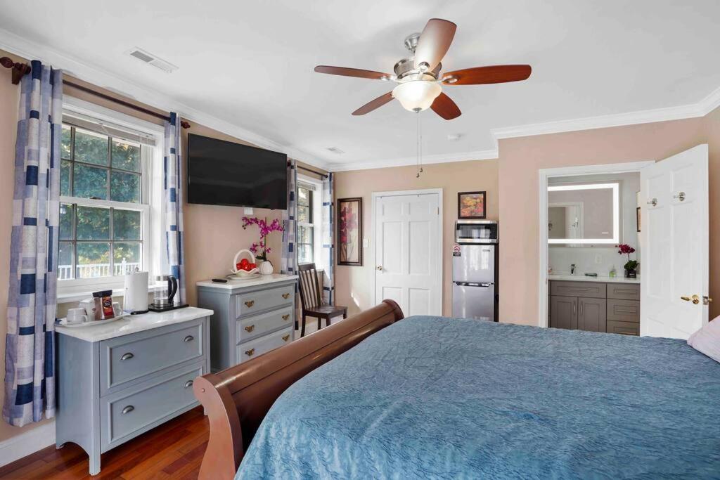 a bedroom with a blue bed with a ceiling fan at Harbor Riverside Property in Fort Washington