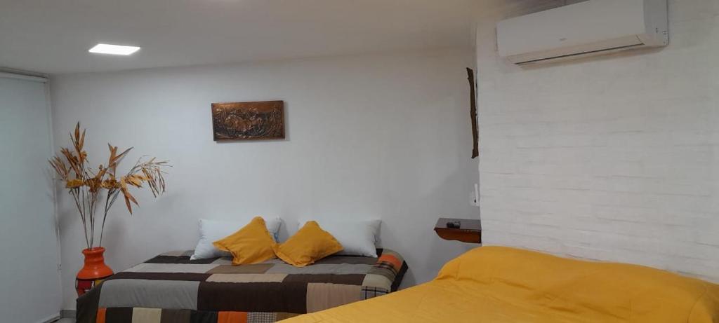 a bedroom with two beds and a painting on the wall at Casa Belén in Toay