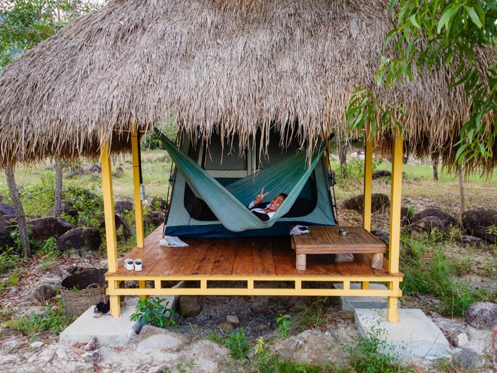 uma pessoa a dormir numa rede numa cabana em Kampot Camping em Kampot