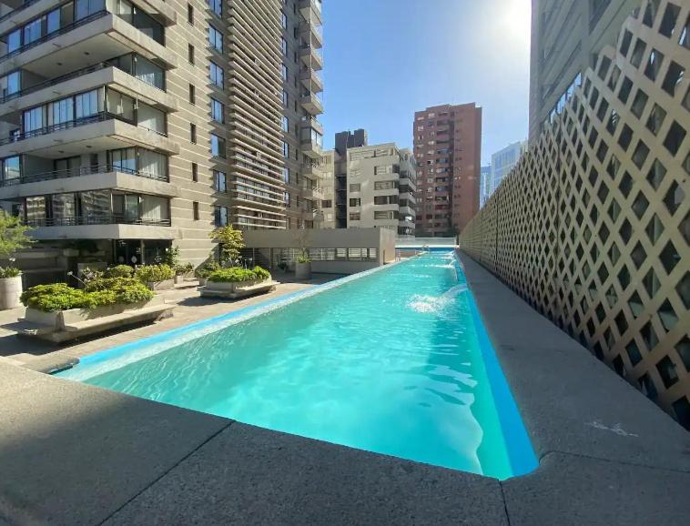une grande piscine dans une ville avec de grands bâtiments dans l'établissement Las Condes, Apartamento para 4 con Piscina, à Santiago