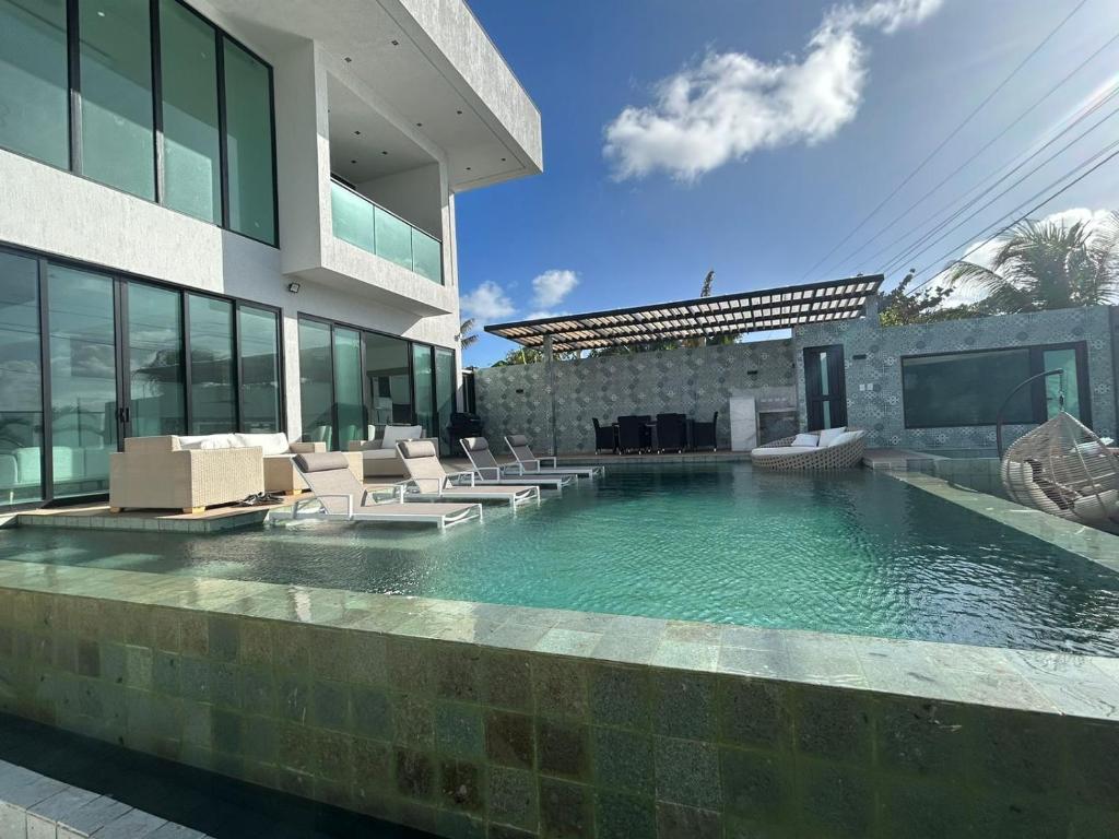 a swimming pool with chairs and a building at Mansión Casa Bali in San Andrés