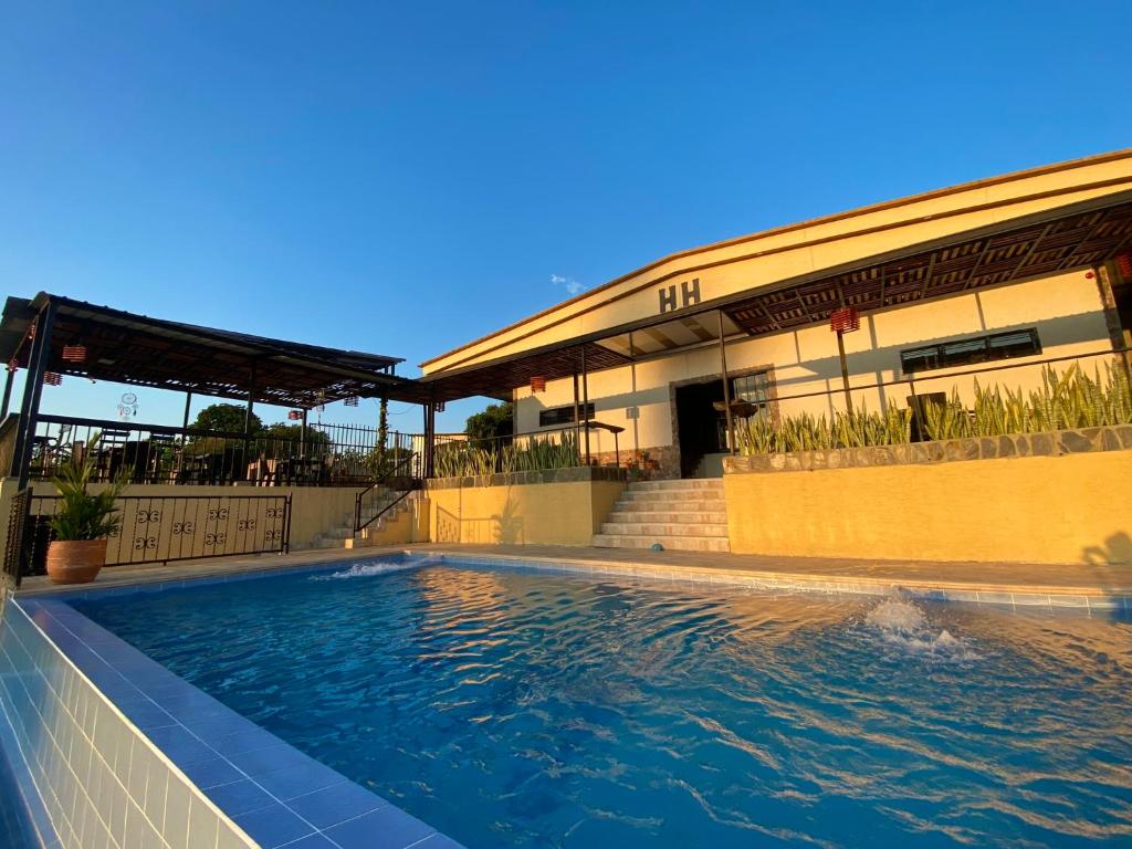 a swimming pool in front of a building at Hotel Casa campestre HH in Quimbaya