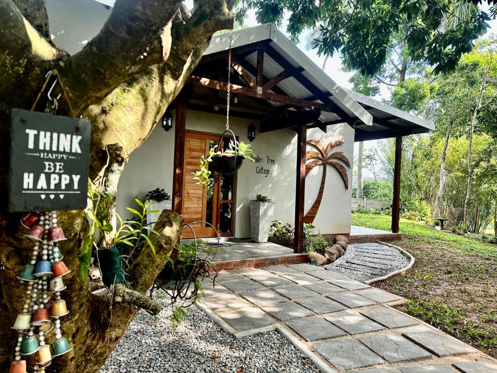 a house with a sign that says think think be happy at Palm Tree Cottage Felixton in Richards Bay