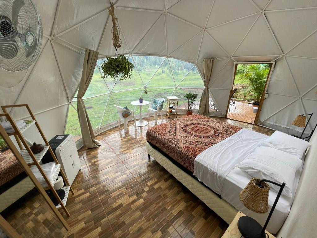 ein Schlafzimmer in einer Jurte mit einem Bett darin in der Unterkunft La Comarca River Glamping Dome near Manuel Antonio in Manuel Antonio