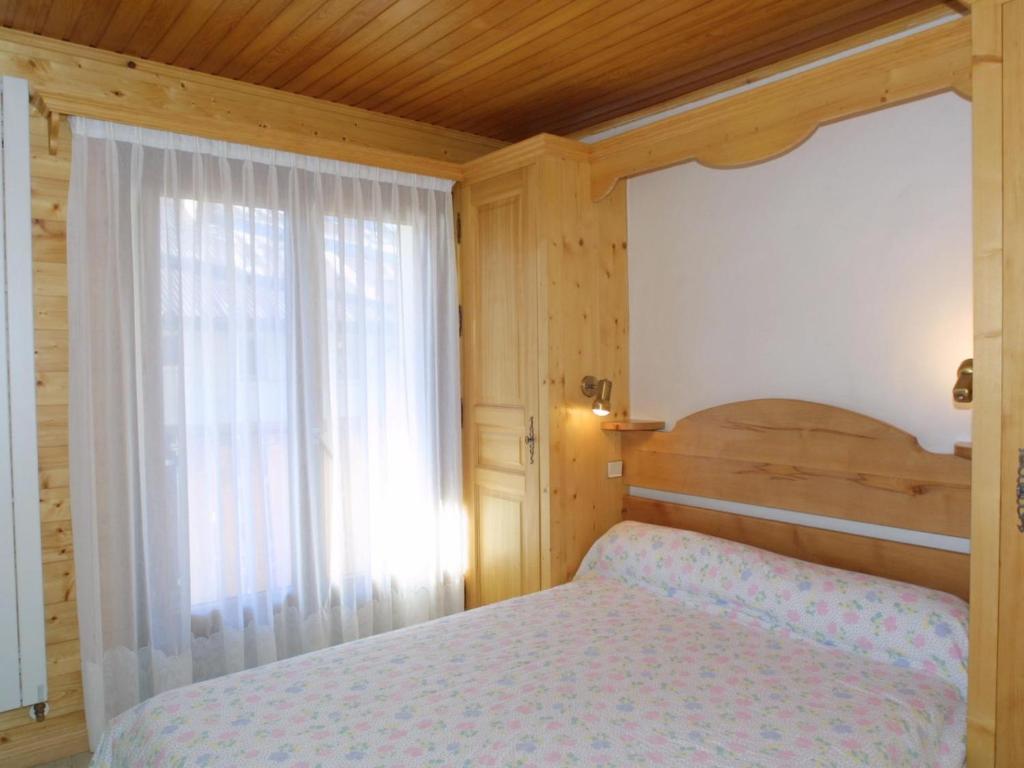 a bedroom with a bed and a large window at Charmant 2 pièces au cœur des Gets, proche télécabines, balcon, Wi-Fi, garage, animaux bienvenus - FR-1-671-137 in Les Gets