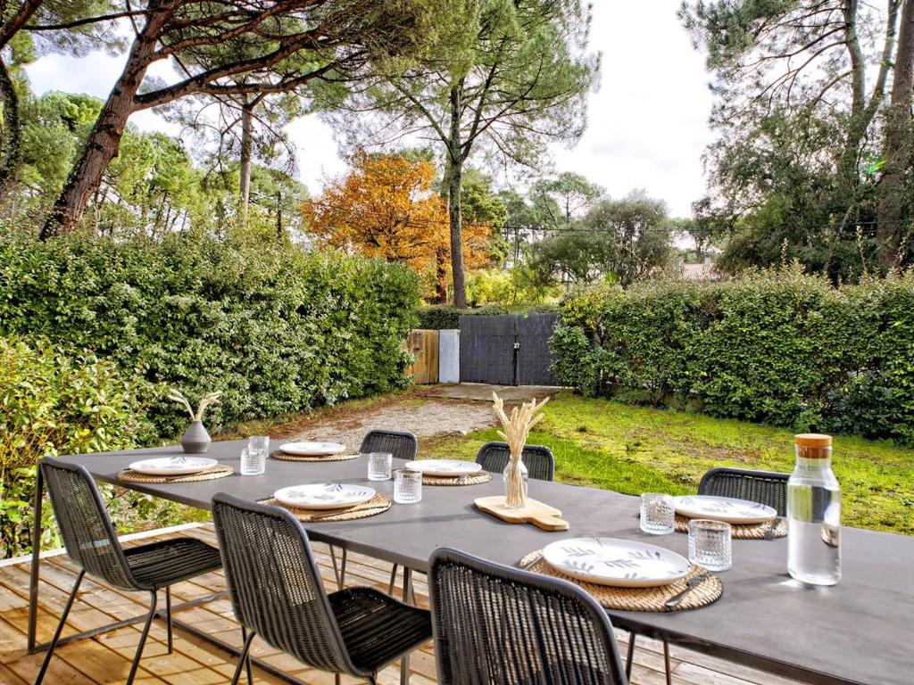 una mesa negra y sillas en un jardín en Villa Pyla-sur-Mer, 3 pièces, 4 personnes - FR-1-433-111, en La Teste-de-Buch