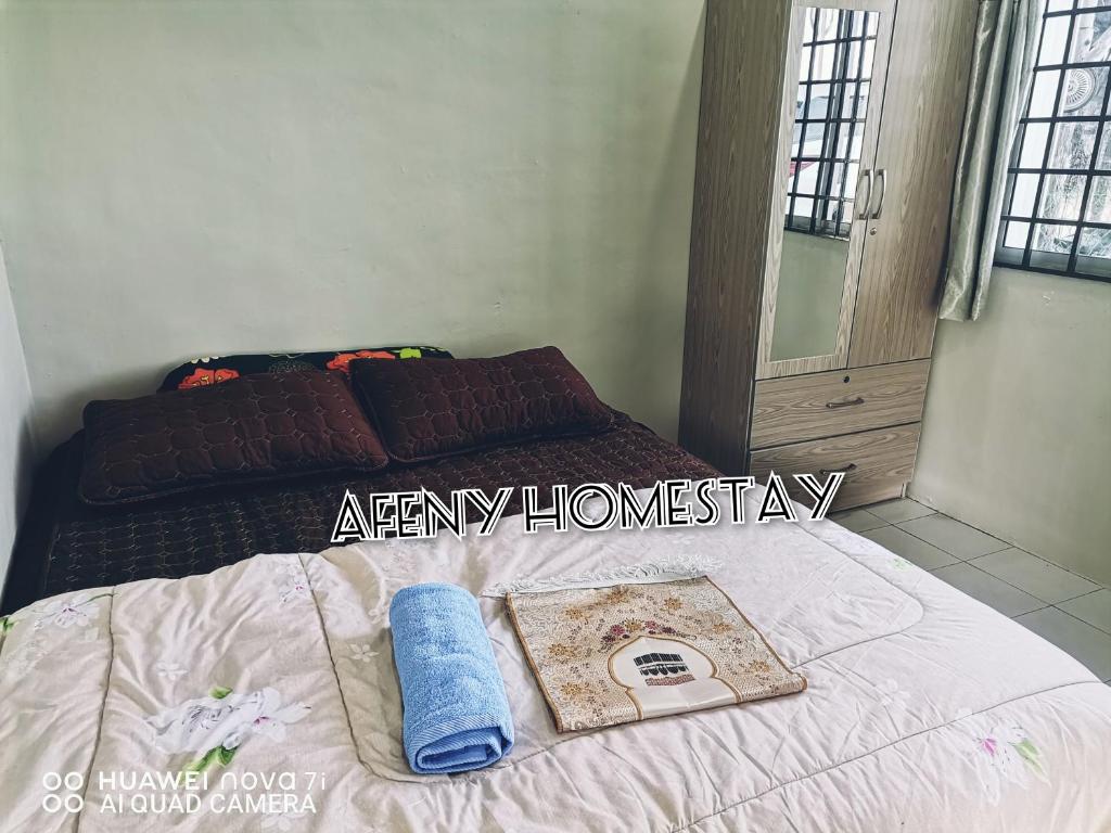 a bedroom with a bed with a book on it at Afeny Homestay in Tawau