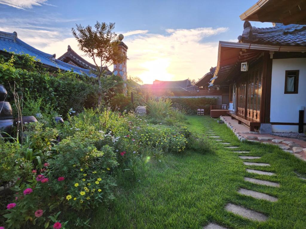 - un jardin avec un sentier et des fleurs dans une cour dans l'établissement Jahayeon Hanokstay, à Jeonju