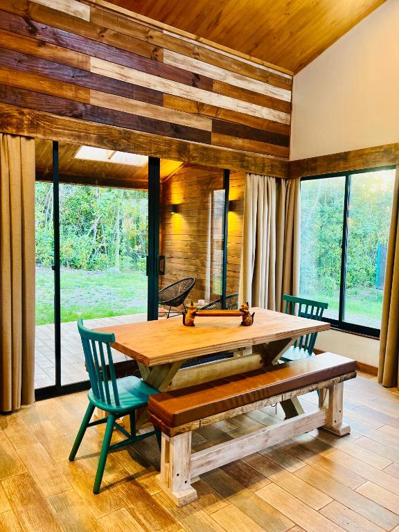 a dining room with a wooden table and chairs at Rümü in Pucón