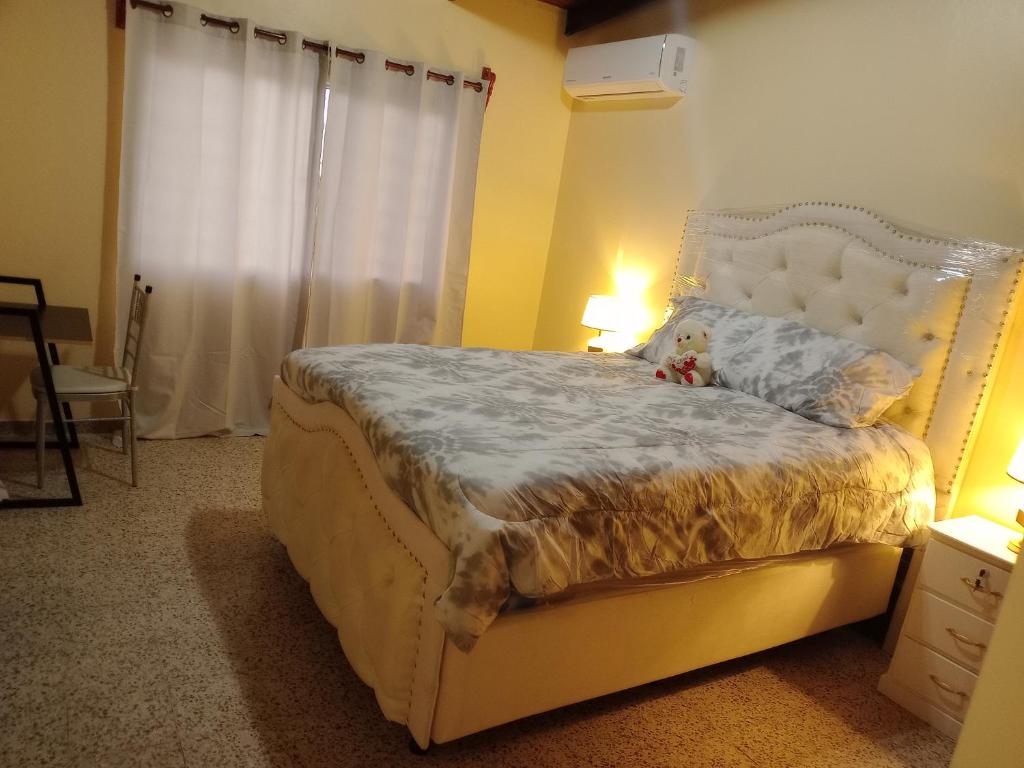 a bedroom with a white bed with a teddy bear on it at Casa hermosa- full amueblada in Tegucigalpa