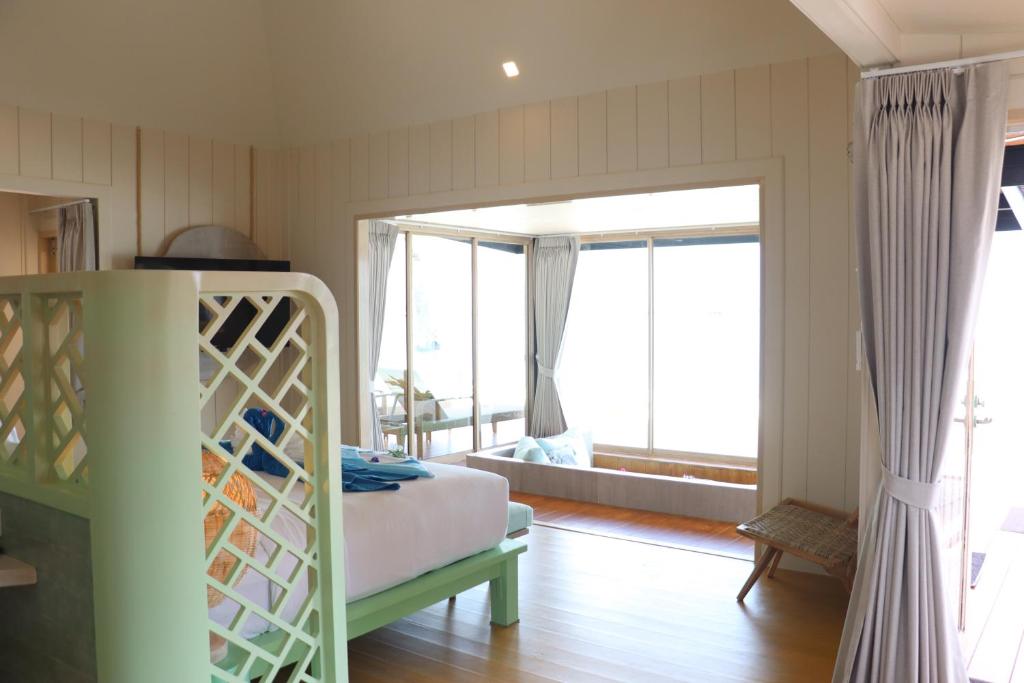 a bedroom with a bed and a large window at Koh Mook Sivalai Beach Resort in Ko Mook