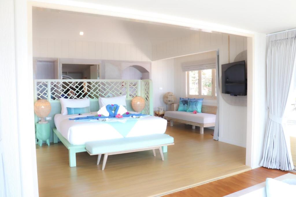 a bedroom with a white bed and a tv at Koh Mook Sivalai Beach Resort in Ko Mook