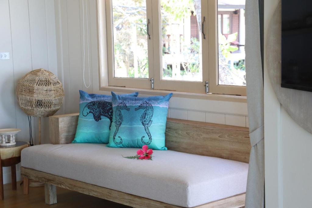 a bench with blue pillows in a room with windows at Koh Mook Sivalai Beach Resort in Ko Mook