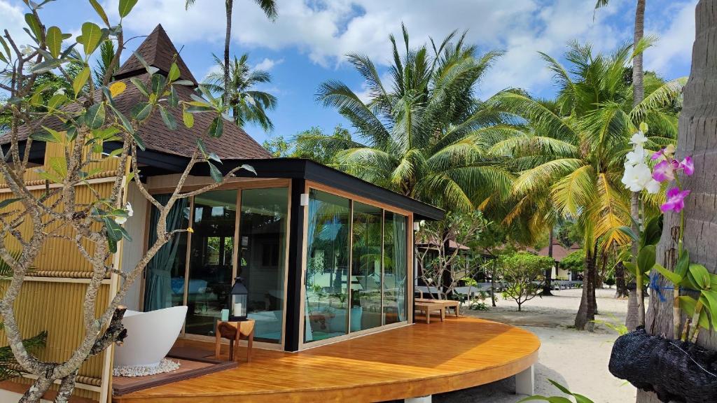 a house on a beach with palm trees at Koh Mook Sivalai Beach Resort in Ko Mook